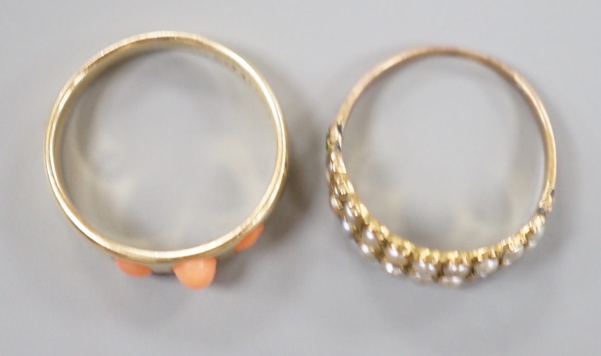 A late Victorian 15ct gold and three stone split coral set ring, size O, gross 3.3 grams and a similar yellow meta seed pearl and garnet set half hoop ring, size N, gross 1.4 grams.